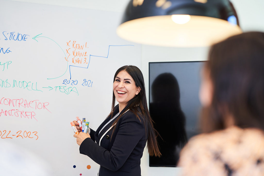 Entreprenören och läkaren Miden Melle-Hannah står framför en whiteboard där hon ritar en mindmap över sitt utvecklingen av sitt företag Multi4.