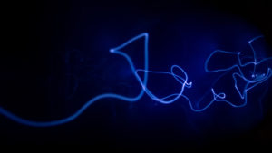 Abstrakt bild av ett blått ljussken som slingrar sig genom en svart bakgrund.