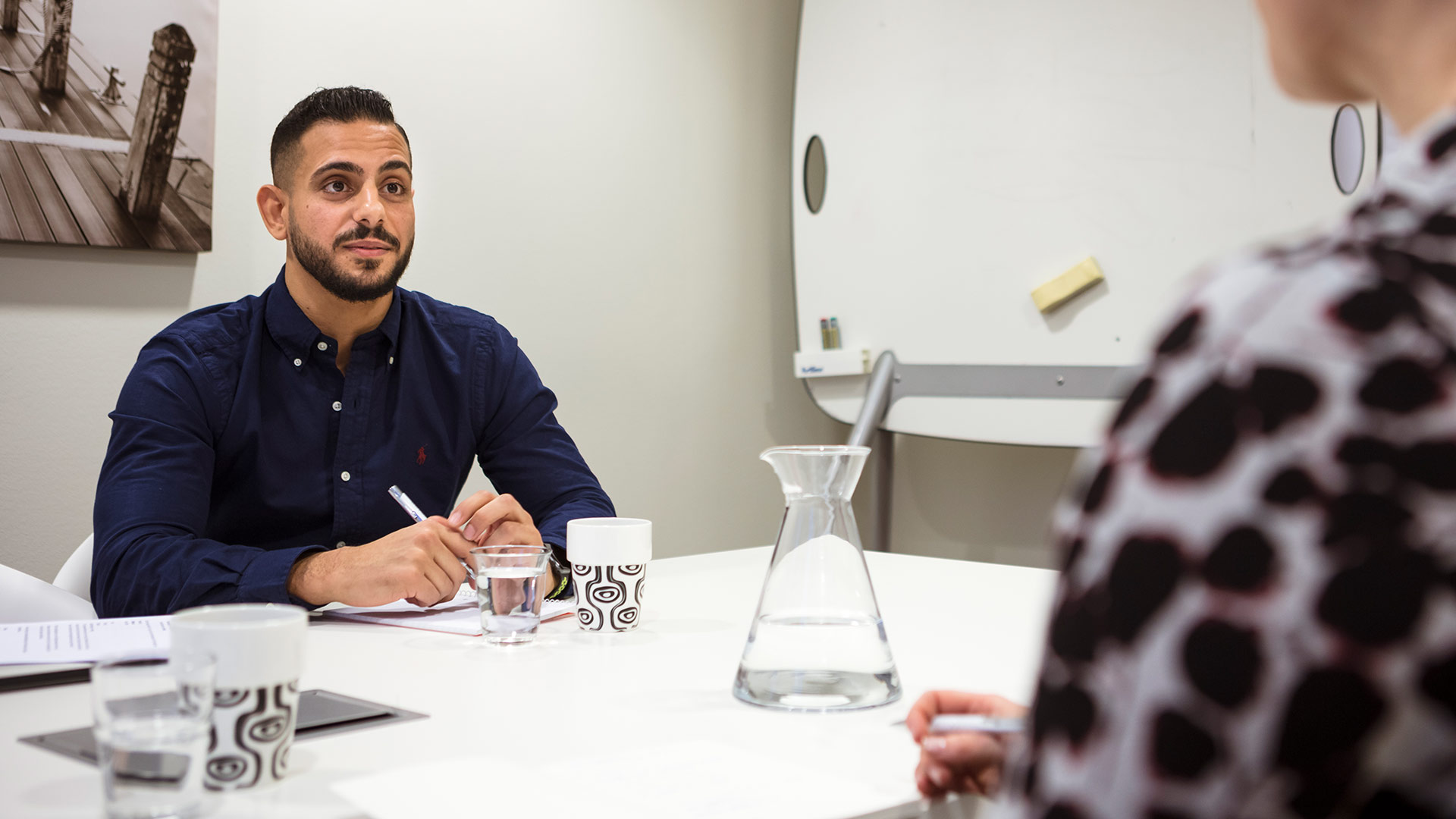 En startupentreprenör sitter i ett mötesrum på Science Park och pratar med en affärsutvecklare.