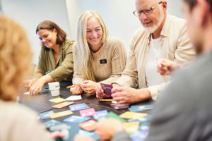 Några av Science PArks anställda sitter vid ett borde och gör en workshop om hållbarhet. De plockar med olika färgglada kort.