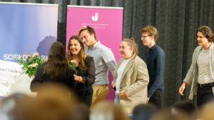 Studenter från JIBS och Tekniska Högskolan i Jönköping går fram på scen för att ta emot förstapriset i Impact Challenge 2023