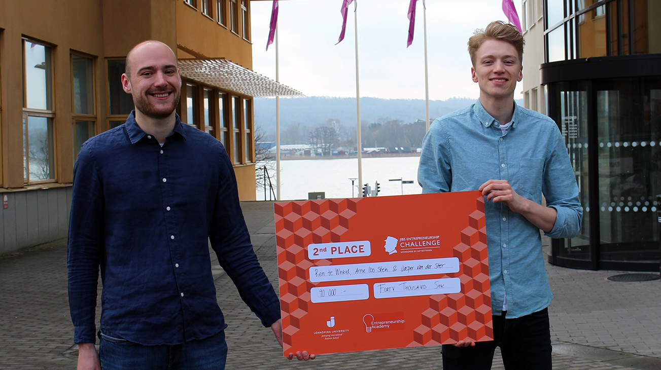 Rein te Winkel och Arne Ibo Stein från Jönköping International Business School står på campus och håller i en prischeck efter att ha vunnit andrapris i en entreprenörskapstävling. 