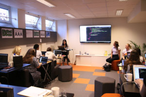 En grupp kvinnor sitter tillsammans i ett konferensrum på Science Park Jönköping för att lära sig grunderna i webbutveckling.