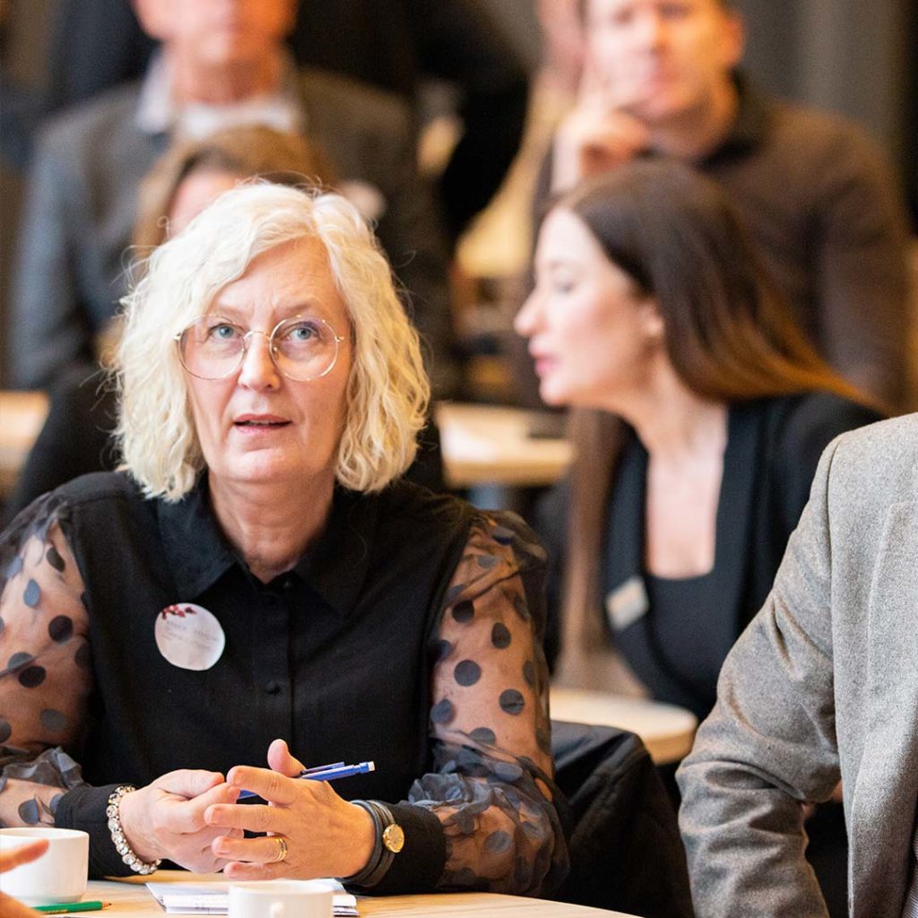 Maude Svensson, Fd. affärsutvecklare på Science Park sitter i en publik och lyssnar fokuserat på en föreläsare