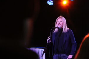 Annie Grönblad som varit med och grundat företaget Trustcruit står på en scen och pratar i en mikrofon.