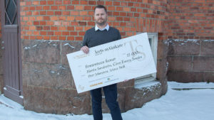 Martin Sundström håller en stor check från Tillväxtstiftelsen i Jönköpings län