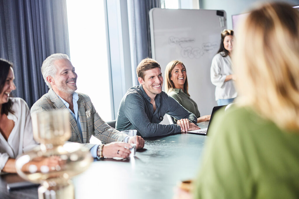 En grupp anställda på Science Park sitter tillsammans i ett mötesrum i Science Park Towers. Rummet är ljust och personerna skrattar.