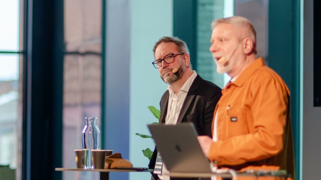 Jörgen Ramnelöv och Bobo af Ekenstam från Docere föreläser. Framför Bobo står en laptop.