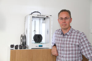 Martin Bondeus som grundat företaget Bondtech står framför en tidig version av sin innovativa 3d-printer.