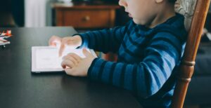 Ett foto på ett barn som leker med en iPad
