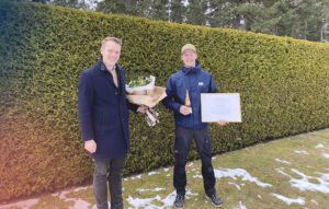 Henning Lindberg delar ut diplom och blommor till Erik Berghiller.