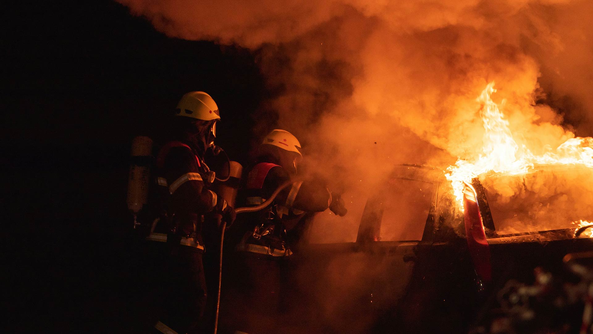 Två brandmän släcker en brand.