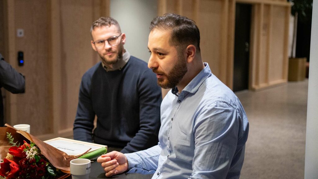 Fadi Chamoun och Lirim Bilibani berättar om Recnote. De sitter vid ett svart bord i Science Park Towers. 